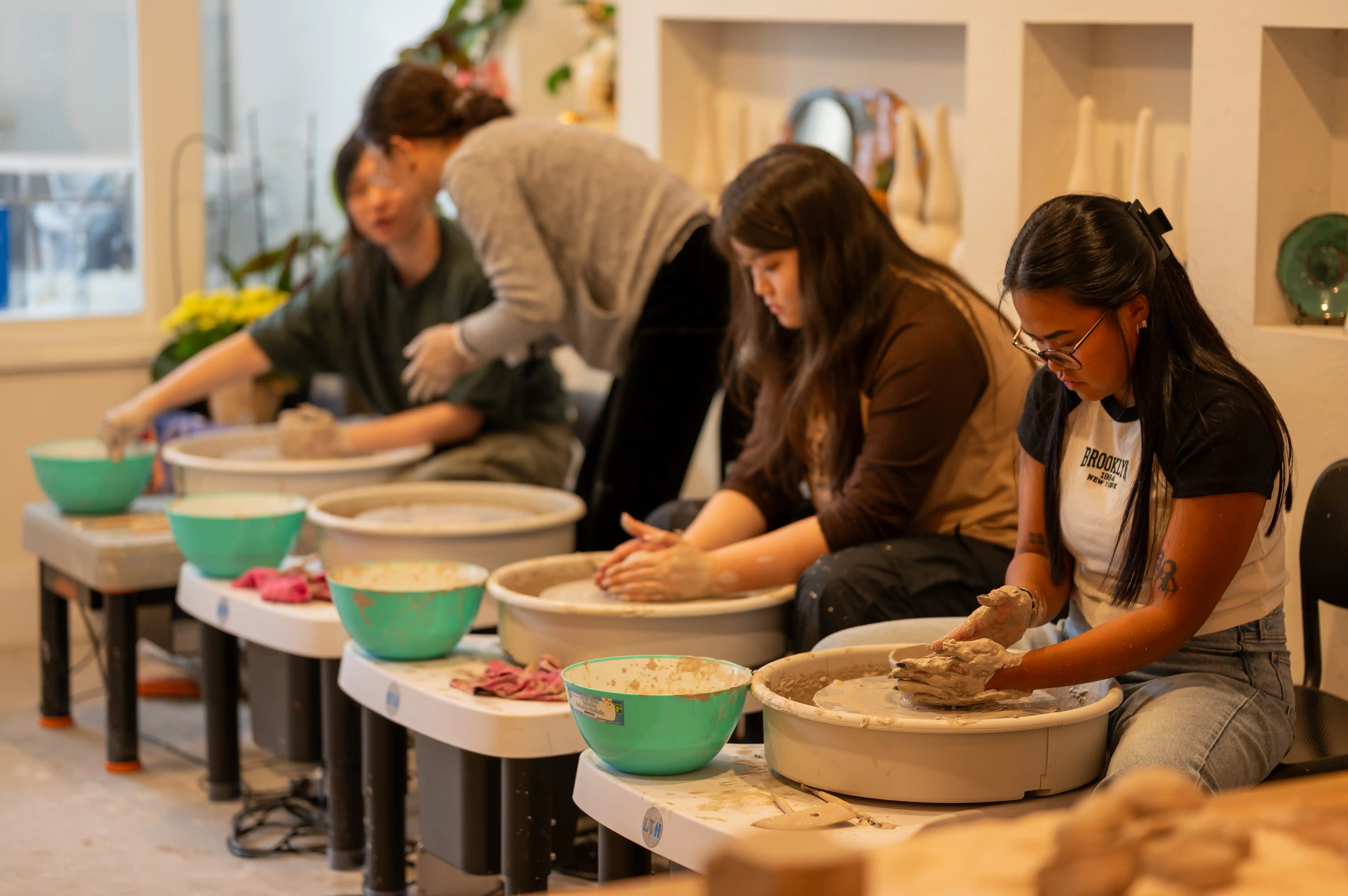 Hands shaping clay on the pottery wheel