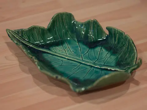 A green leaf-shaped platter with carved veins