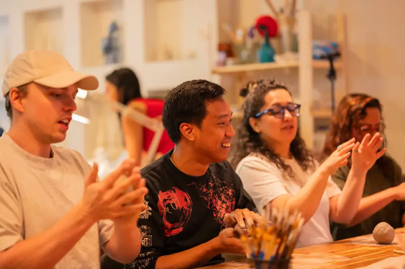 The joy and satisfaction of students during their pottery workshop experience.