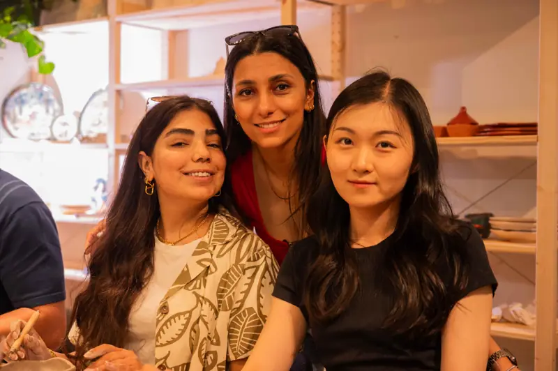 Three workshop participants enjoying their pottery class experience together.