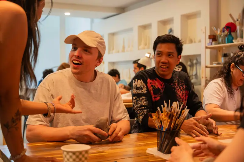 Students sharing laughs and enjoying their pottery workshop experience at Lemarsis Studio.