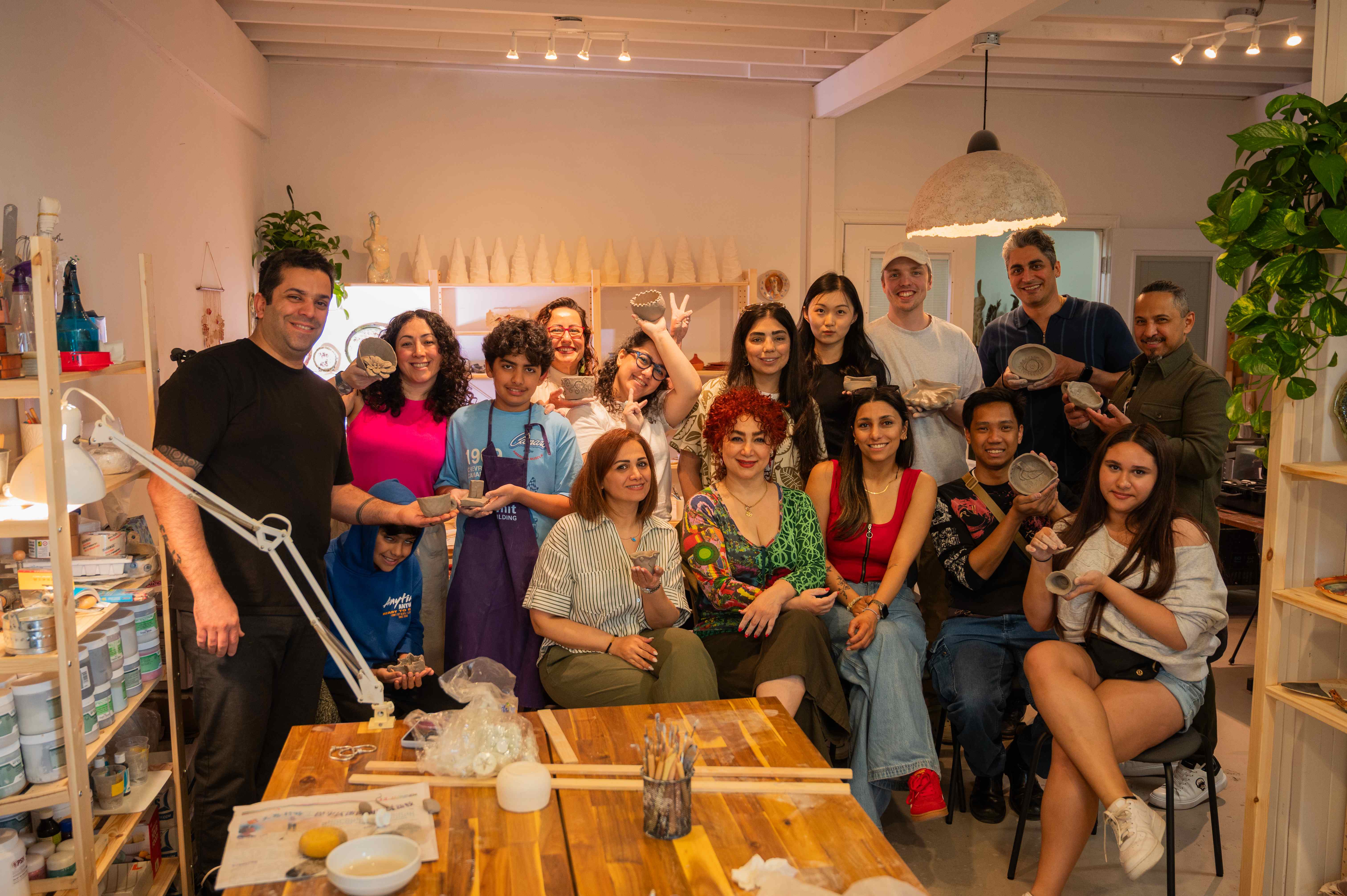Happy pottery students showing their ceramic creations at Lemarsis Studio
